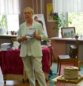 Julija Tolmačova ezittelöy kniigua Kindahan kylän vezimelličäs Priäžän etnokul'tuurukeskukses